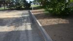 Upravený terén za obrubníky na parkovišti u hřbitova